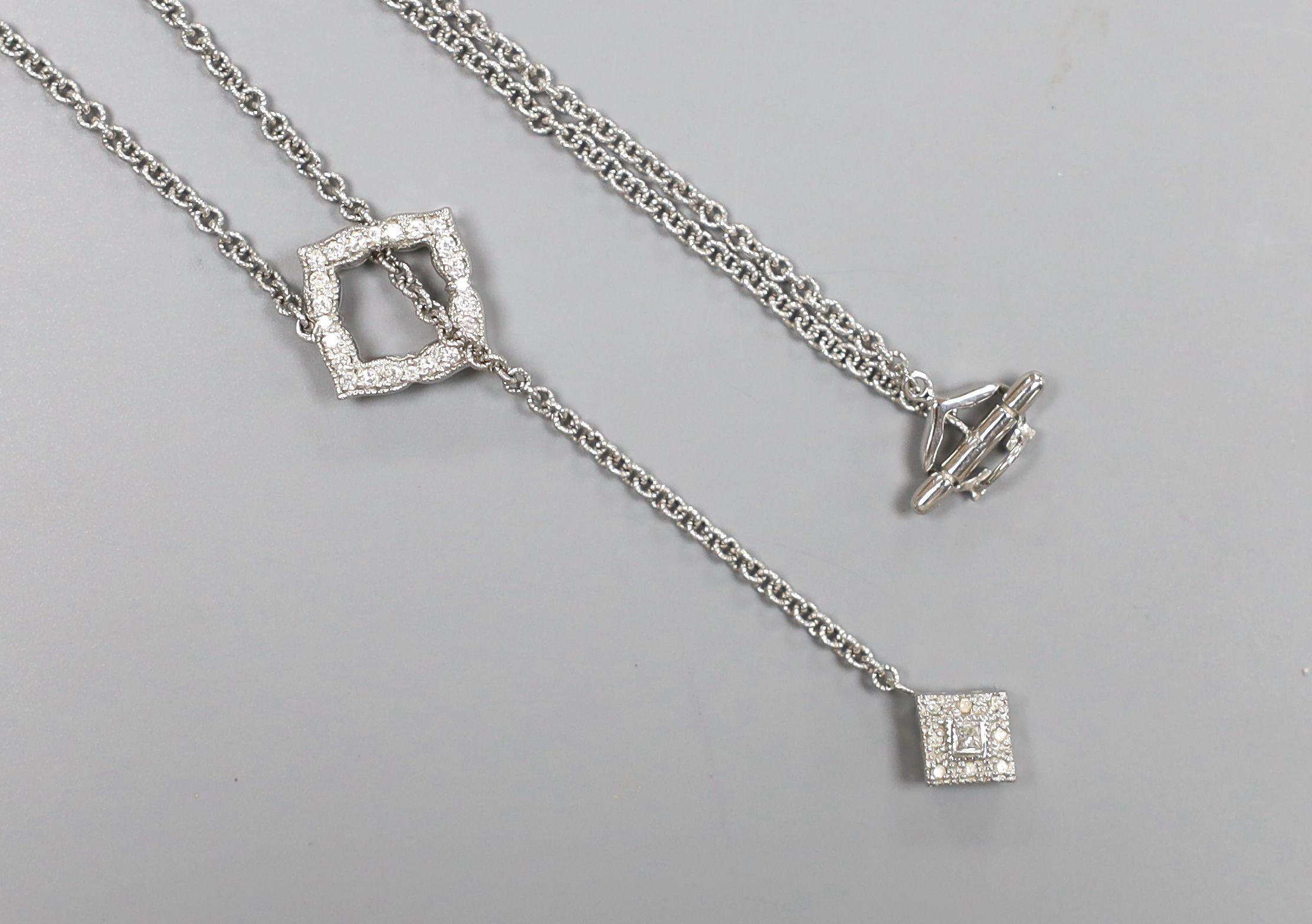 A modern 750 white metal and diamond cluster set drop necklace, 54cm, gross weight 10 grams.